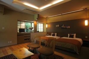 白石市托基恩诺亚都玉努时其乔旅馆的酒店客房带两张床和一张桌子以及椅子。