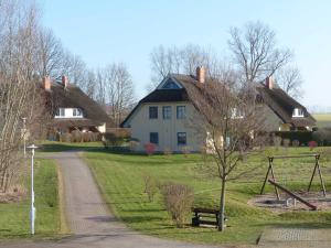 布德明Behagliches Reetdachhaus Eibe 1的草屋顶和道路的房子