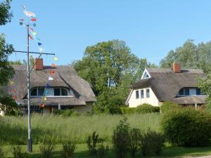 布德明Behagliches Reetdachhaus Eibe 1的前面有旗帜的房子