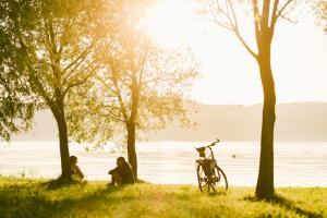 格尔利茨Insel der Sinne的两个人坐在水边的草上,骑着自行车
