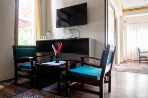 列城Hotel Wangchen的客厅配有桌椅和电视。