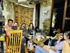 罕萨Backpackers Stories by Old Hunza Inn的一群人坐在餐馆的桌子旁