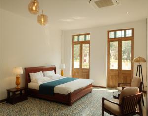 琅勃拉邦PHA NYA RESIDENCE的一间卧室配有一张床、一把椅子和窗户。