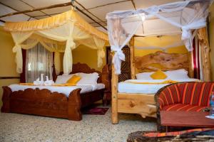 OlolaimutiekExplore Nature Lodge的一间卧室设有两张天蓬床和一张沙发