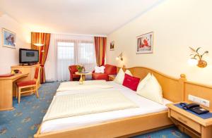 玛丽亚阿尔姆伯格乌尔斯劳霍夫温泉酒店的酒店客房设有床和客厅。