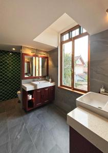 琅勃拉邦PHA NYA RESIDENCE的一间带两个盥洗盆的浴室和一个大窗户