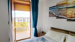 坎波马里诺Il bacio del sole的一间卧室设有一张床,享有阳台的景色