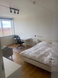 哥本哈根Studio apartment in Copenhagen.的一间卧室配有一张床、一张桌子和一把椅子