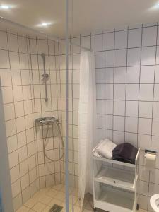 哥本哈根Studio apartment in Copenhagen.的带淋浴和盥洗盆的白色瓷砖浴室