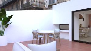 赫罗纳El Refugi de Girona的阳台配有桌椅和桌子