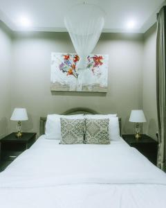 阿鲁沙The Hatua Peaceful Homeaway Haven的卧室配有带两盏灯的白色床