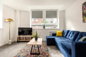 罗瑟勒姆Bright 1 Bedroom Apartment in Central Rotherham的客厅配有蓝色的沙发和电视