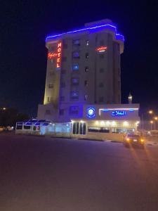 科威特Spice Hotel的一座大建筑,晚上有蓝色的灯光