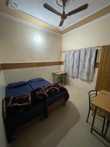 德拉敦Omjee Paying Guest的一间卧室配有一张床和吊扇