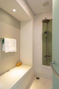 富国富国岛贝壳Spa度假酒店 的墙上设有淋浴和毛巾的浴室