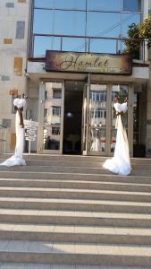 巴克乌Hamlet Hotel的两座新娘和新郎的雕像,在一座建筑物前