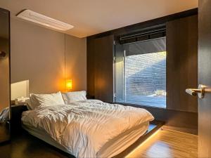 釜山Banwol Poolvilla的一间卧室设有一张床和一个窗口