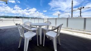 鹿儿岛Apartment Hotel Ecott的阳台配有一张桌子和四把椅子