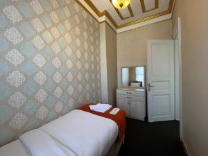 伊斯坦布尔Le Safran Suite Hotel的一间小卧室,配有一张床和镜子