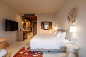 大城Centara Ayutthaya的卧室配有白色的床和电视。