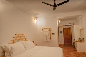 希曼杜岛Manta Sea View Himandhoo的卧室配有白色的床和吊扇