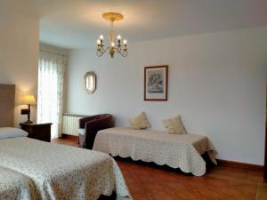 朗格勒Hosteria De Langre的一间卧室配有两张床和吊灯。