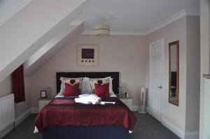 托基胡椒酒店的一间卧室配有一张红色床罩的床