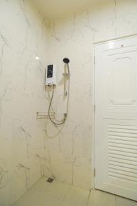 班杜Kandanai Place的带淋浴的浴室,墙上配有电话