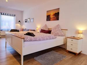 OesterdeichstrichSchönes 1-Zimmer-Appartement, Büsum (4km) Nordsee的卧室配有一张白色的大床和床头柜。