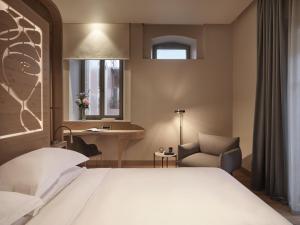 干尼亚Domus Blanc Boutique Hotel的卧室配有床、椅子和窗户。