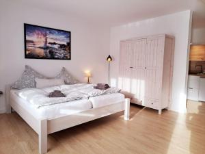 OesterdeichstrichRuhiges 1-Zimmer-Appartement, Büsum (4km), Nordsee的一间白色卧室,房间内设有一张大白色的床