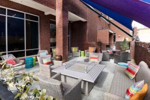罗利汉普顿酒店及套房 - 罗利市中心的庭院配有藤椅和桌子