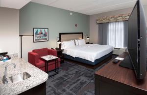 罗利汉普顿酒店及套房 - 罗利市中心的酒店客房,配有一张床和一张红色椅子
