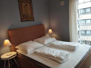 慕尼黑Amalien 12的卧室配有带白色枕头的床和窗户。