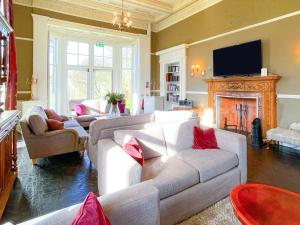 ArnistonThe Mansion House At Kirkhill的客厅配有白色沙发和壁炉