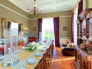 ArnistonThe Mansion House At Kirkhill的大型用餐室配有长桌和椅子