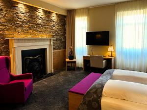 希莱斯海姆Augustiner Hotel的酒店客房配有一张床和一个壁炉。