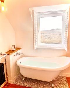 GarrabostKinnoull House near Stornoway Hot Tub/Pet Friendly的带窗户的浴室内的白色浴缸