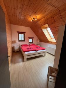 特尔日奇Holiday Home Planina的阁楼卧室配有红色床