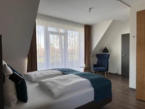 威廉港Hotel Schöne Aussicht的一间卧室配有一张大床和一张蓝色椅子