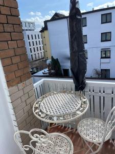 腓特烈港Casa Pinos City的阳台配有一张桌子和两把椅子以及一把遮阳伞。