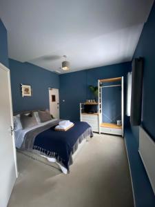 珀肖尔Pershore Rooms at The Star的一间卧室设有一张床和蓝色的墙壁