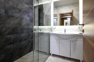 InđijaMonogramlux的一间带水槽和玻璃淋浴的浴室