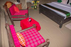 OlolaimutiekMara Olodare的一间设有两把椅子、一张桌子和一张床的房间