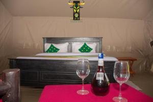 OlolaimutiekMara Olodare的桌子上放着两杯葡萄酒,还有一张床