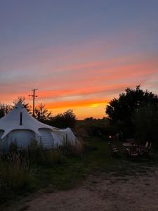 诺里奇Moat Island Glamping的圆顶帐篷,背景是日落