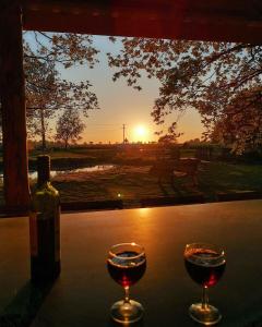 诺里奇Moat Island Glamping的两杯酒坐在桌子上,欣赏日落美景