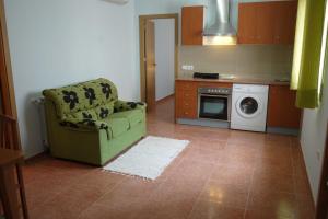 昆卡RC拉蒙y卡耶尔酒店的厨房配有绿色椅子和洗衣机