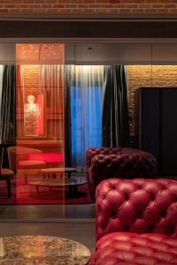马德里Casa Faraona Luxury Residences的客厅配有红色的沙发和桌子