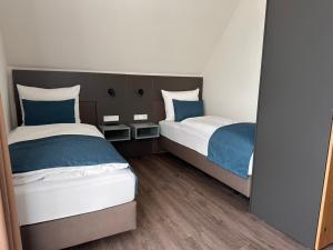 威廉港Hotel Schöne Aussicht的蓝色和白色的客房内的两张床